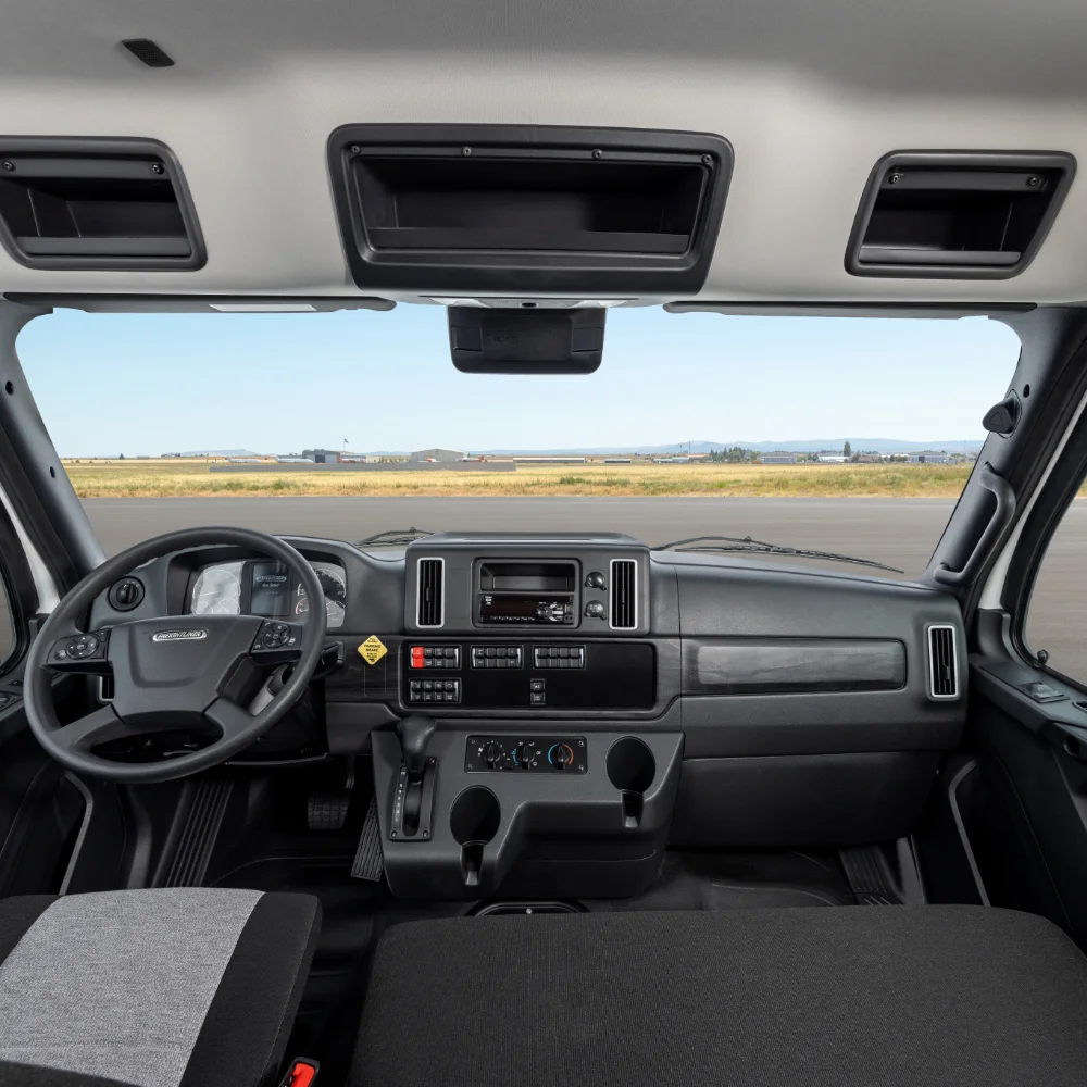 Freightliner M2 112 Plus Series truck dashboard and driver's seat perspective with clear view through the windshield